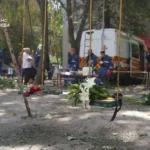 Кияни несуть квіти до знищеного росіянами будинку, де тривають пошукові роботи (фото)